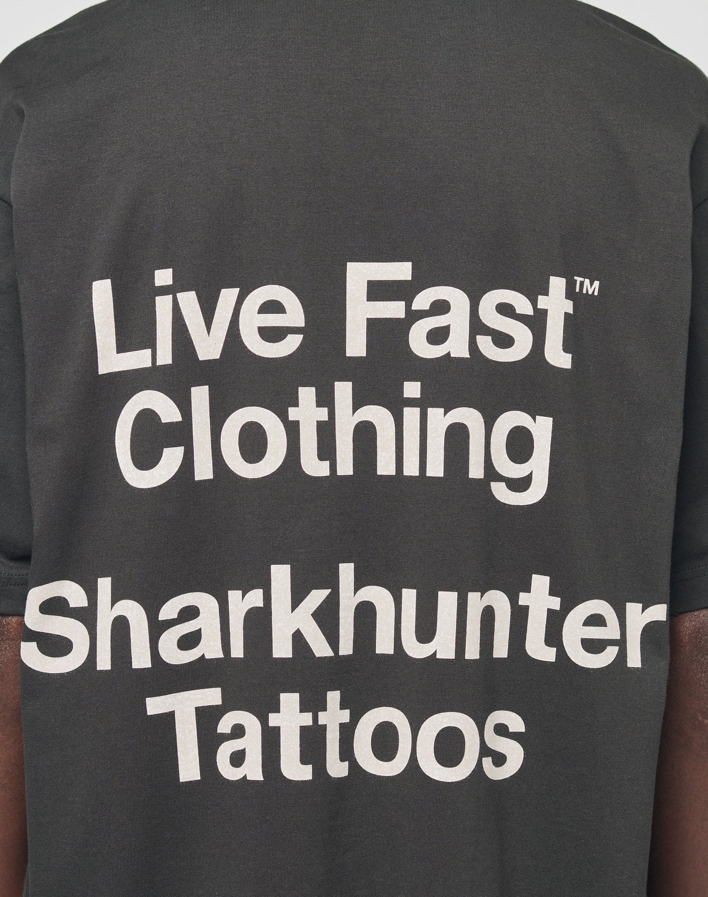 A close-up of the LFDY Sharkhunter Tee by LIVE FAST DIE YOUNG, a black cotton shirt with bold white Sharkhunter Tattoos print, featuring a trendy oversized fit.