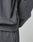 Close-up of a person in the LIVE FAST DIE YOUNG DY Sweater and matching pants. The dark gray cotton fabric shows subtle wrinkles, and a small sewn tag accents the side seam of the Raglan-sleeved sweatshirt.