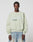 A man with braided hair wears a light green LFDY Vandals Sweater by LIVE FAST DIE YOUNG in Oversize Fit and light blue baggy jeans, standing against a plain white background.