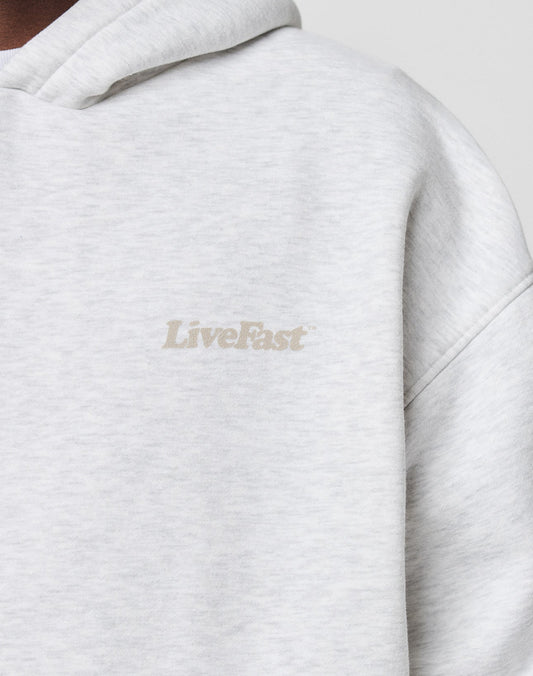 Close-up of the light gray Basic 360 Hooded by LIVE FAST DIE YOUNG in Oversize Fit, featuring LiveFast printed in small, subtle, light-colored letters on the left chest.