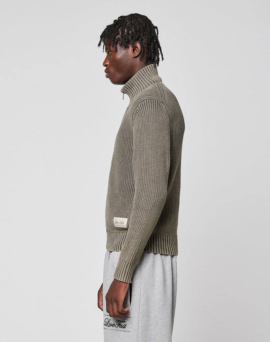 A person stands in profile wearing the LIVE FAST DIE YOUNG LFDY Knit Jacket with a stand-up collar and light gray sweatpants against a plain light gray background.