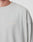 A close-up of a person wearing an oversize fit, light gray LIVE FAST DIE YOUNG Basic Longsleeve made from 100% Baumwolle, featuring a subtle logo print on the left chest. Only part of the neck and shoulder is visible.