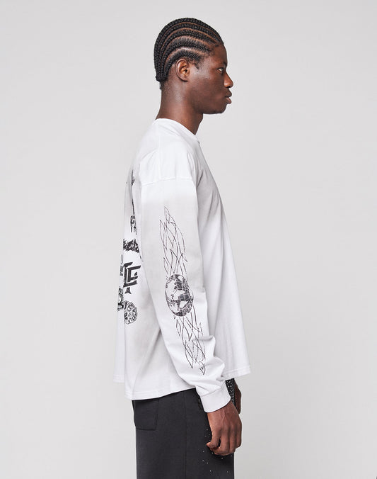 A person with braided hair stands in profile against a light background, wearing the LIVE FAST DIE YOUNG LFDY Logo Longsleeve—an oversized white shirt featuring black graphic designs on the back and sleeves.