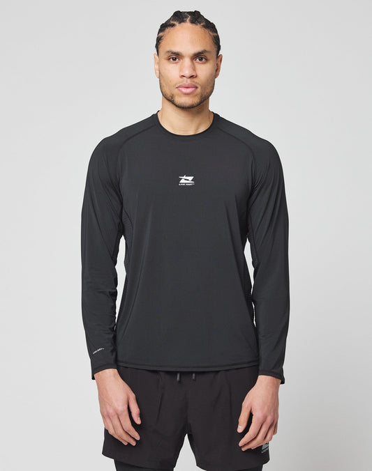 A man with braided hair wears the LIVE FAST DIE YOUNG Live Fast Performance Longsleeve in black and matching black shorts, standing facing forward against a plain light gray background. | model