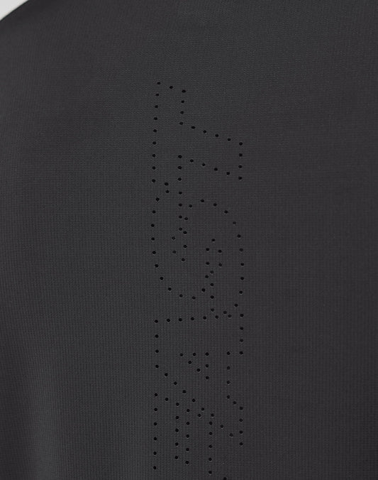 Close-up of the Live Fast Performance Longsleeve by LIVE FAST DIE YOUNG, showing black fabric with a mesh insert and perforated holes forming FAST vertically, highlighting the garment’s texture and fine details.