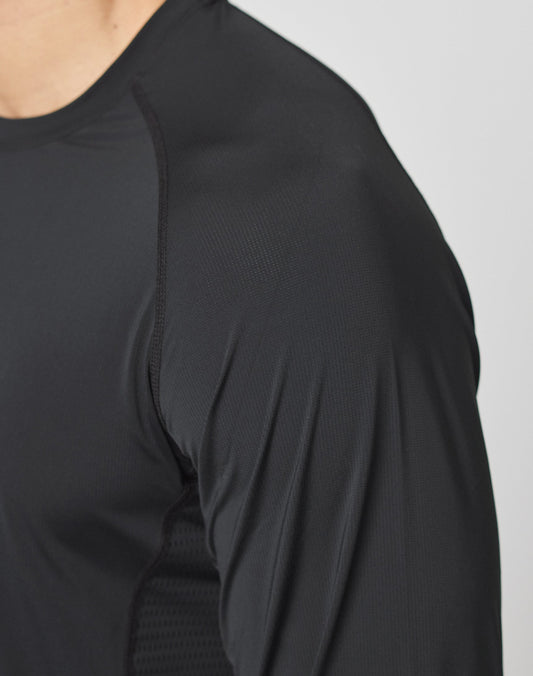 A close-up of a person wearing the LIVE FAST DIE YOUNG Live Fast Performance Longsleeve in black, featuring a slim fit and lightweight, moisture-wicking fabric. The image highlights the shoulder, upper arm, and part of the chest.
