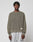 A man with short twists wears the LIVE FAST DIE YOUNG LFDY Knit Sweater, an oversized ribbed olive-green piece in 100% cotton, paired with light gray sweatpants. He stands facing forward against a plain light gray background.