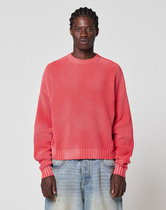 A person with braided hair wears the LFDY Washed Knit Sweater by LIVE FAST DIE YOUNG and faded light blue jeans, standing against a plain white background.