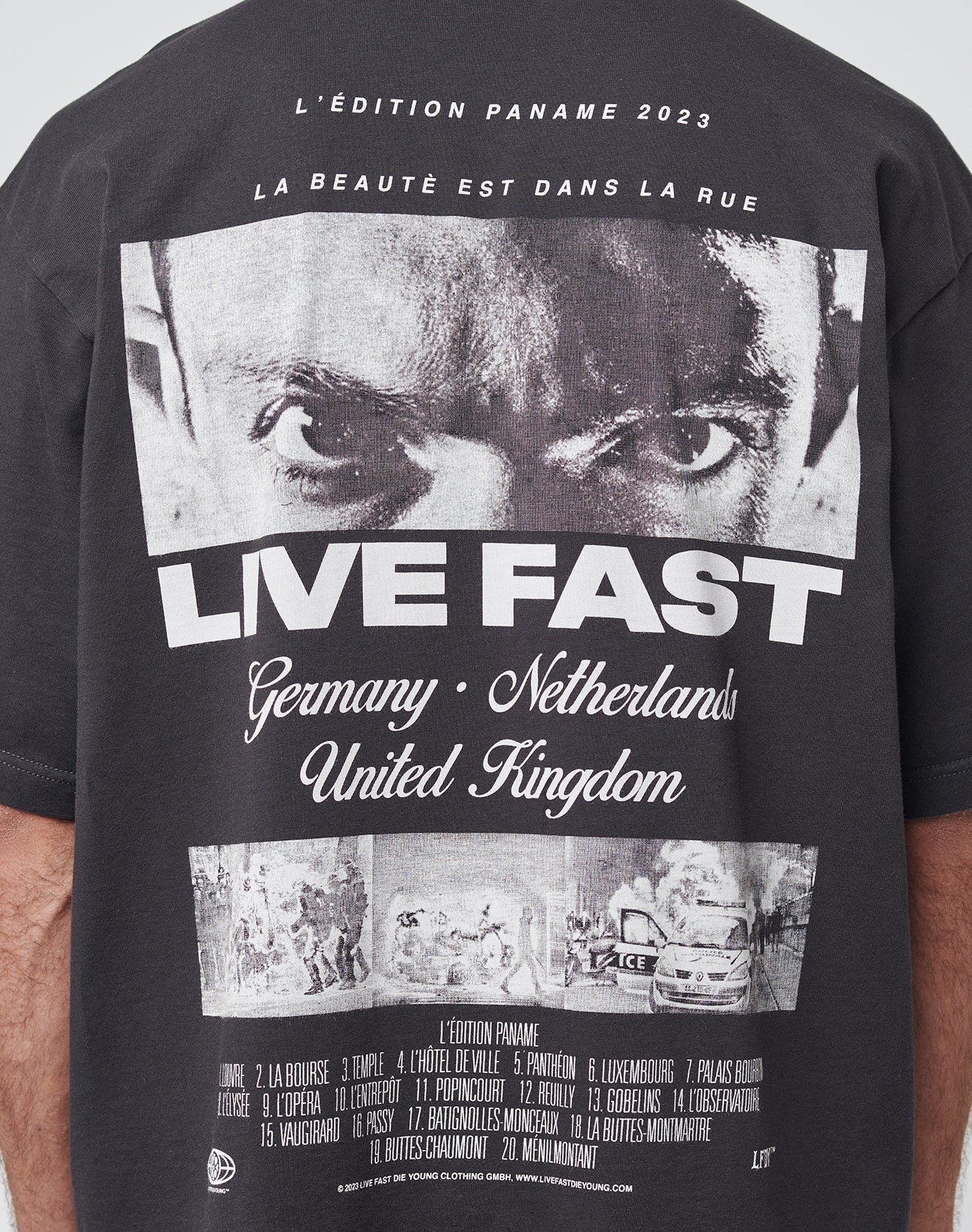 The LFDY Cinema Tee by LIVE FAST DIE YOUNG is an oversize black cotton t-shirt featuring a bold face graphic, LIVE FAST text, and Germany • Netherlands • United Kingdom with icons and French wording at the bottom.