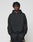 A young man with short, twisted hair wears a black LIVE FAST DIE YOUNG Basic Blank Hooded and black athletic pants, standing against a plain light gray background. He looks directly at the camera with a neutral expression.