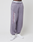A person wears loose-fitting, purple-grey LFDY Hotline Loose Jogger by LIVE FAST DIE YOUNG with a white and red "Approval GUARANTEED +49 Live Fast" print on the leg, white sneakers, and an Elastikbund for comfort. Only the lower body is shown.