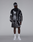 A man poses against a plain background wearing the LIVE FAST DIE YOUNG LFDY Performance Jacket with matching shorts, white socks and sneakers, and a coordinating cap. The outfit features an allover black and white print with reflective logo sleeves.