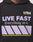 A person wears the LFDY Racing Hooded by LIVE FAST DIE YOUNG: an oversized black hoodie with glossy LFDA LIVE FAST Everything in it. print in purple and white, a yellow-striped graphic, and LIVEFASTDIEYOUNG.COM on the chest.