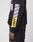 A person wears the LFDY Racing Hooded by LIVE FAST DIE YOUNG—an oversize black sweatshirt with lavender and yellow glossy LFDY designs on the sleeve. Their hand is visible against a plain light gray background.