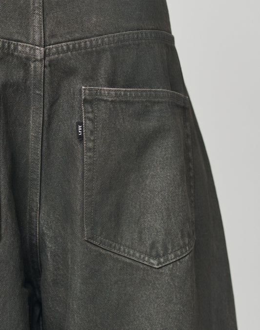 Close-up of the back pocket on LFDY Coated Baggy Denim by LIVE FAST DIE YOUNG, featuring dark gray 100% Baumwolle fabric, detailed stitching, a small black tag with white text, and a gerades Bein for a modern look.