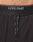 Close-up of a person’s lower torso wearing Live Fast Performance Running Shorts by LIVE FAST DIE YOUNG. The black shorts have an elastic waistband with white LIVE FAST branding and black drawstrings with white text in front.