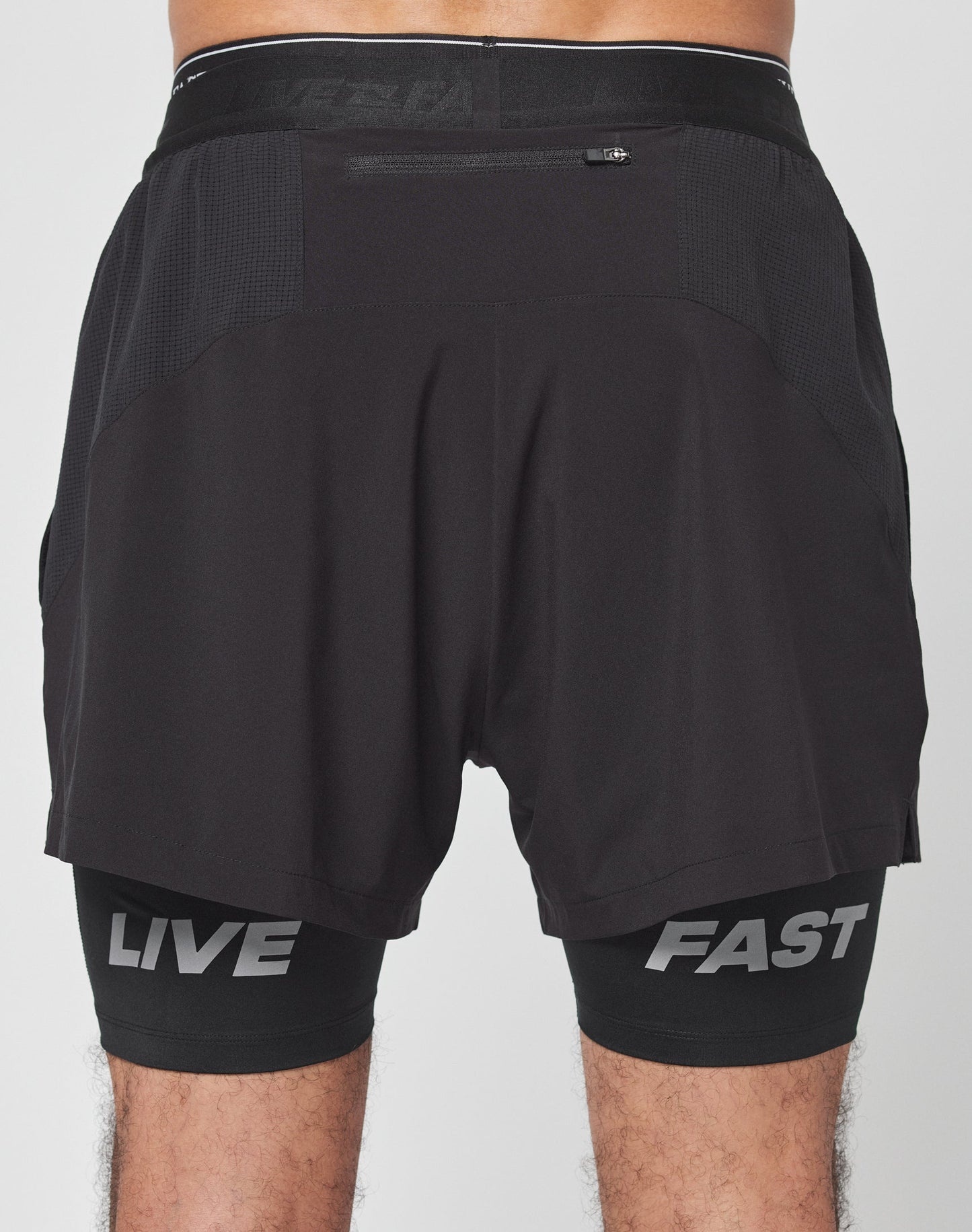 Close-up of Live Fast Performance Running Shorts by LIVE FAST DIE YOUNG, featuring a textured mesh panel, branded detailing, and a zippered side pocket with a small zipper pull.