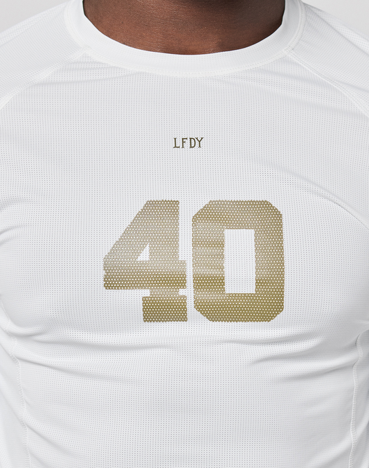 A person wears the LFDY Performance Slim Longsleeve from LIVE FAST DIE YOUNG, featuring a white design, gold number 40, small “LFDY” above the chest numbers, and a mesh insert for breathability.