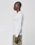 A man stands in profile against a plain background, wearing a LIVE FAST DIE YOUNG LFDY Performance Slim Longsleeve in white and green camouflage shorts made from lightweight material.