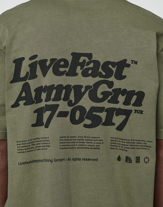 Back of an olive green Basic 210 Tee by LIVE FAST DIE YOUNG with bold black "LiveFast Army Grn 17-0517" text, smaller details about Army Green, 100% Baumwolle, brand name, and various small icons at the bottom.