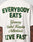 Someone wears the LIVE FAST DIE YOUNG Everybody Eats Tee, an oversized white 100% Baumwolle shirt with bold EVERYBODY EAT$ text, Germany/UK/Netherlands in the center, LIVE FAST at the bottom, plus a backprint.
