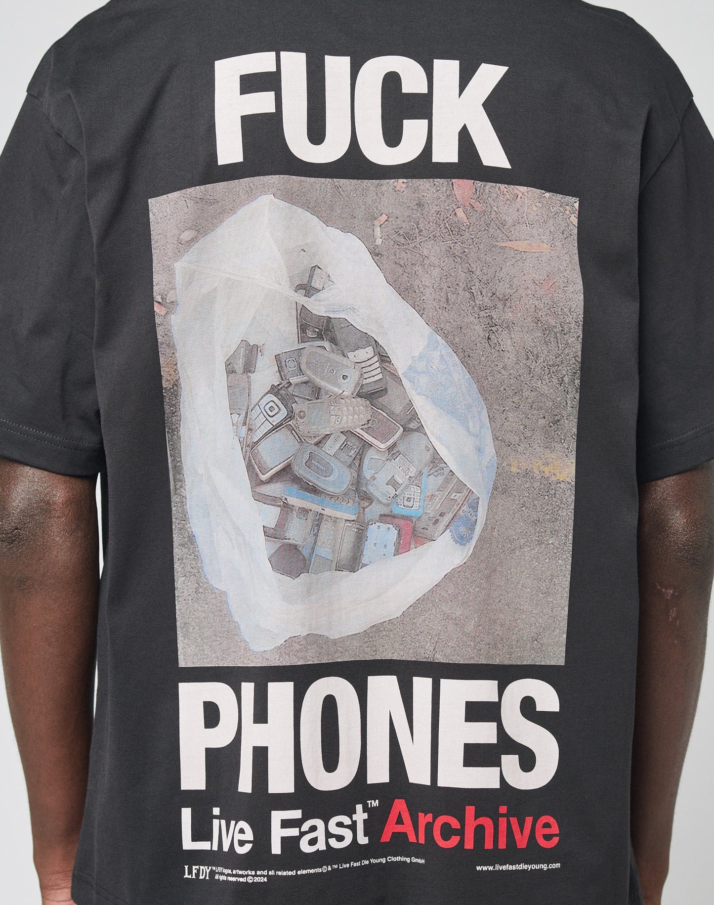 The LFDY F*ck Phones Tee by LIVE FAST DIE YOUNG features an oversized black fit with bold “FUCK PHONES” text above a graphic of old phones and “Live Fast Archive” below, crafted from soft Baumwolle for comfort.