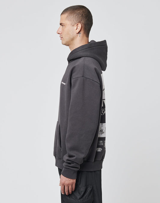 A man in profile stands against a plain background, wearing the LFDY Cinema Hooded by LIVE FAST DIE YOUNG—an oversize-fit dark gray hoodie with a graphic back, black pants, and hood up. Made from comfortable Baumwolle-Polyester material.