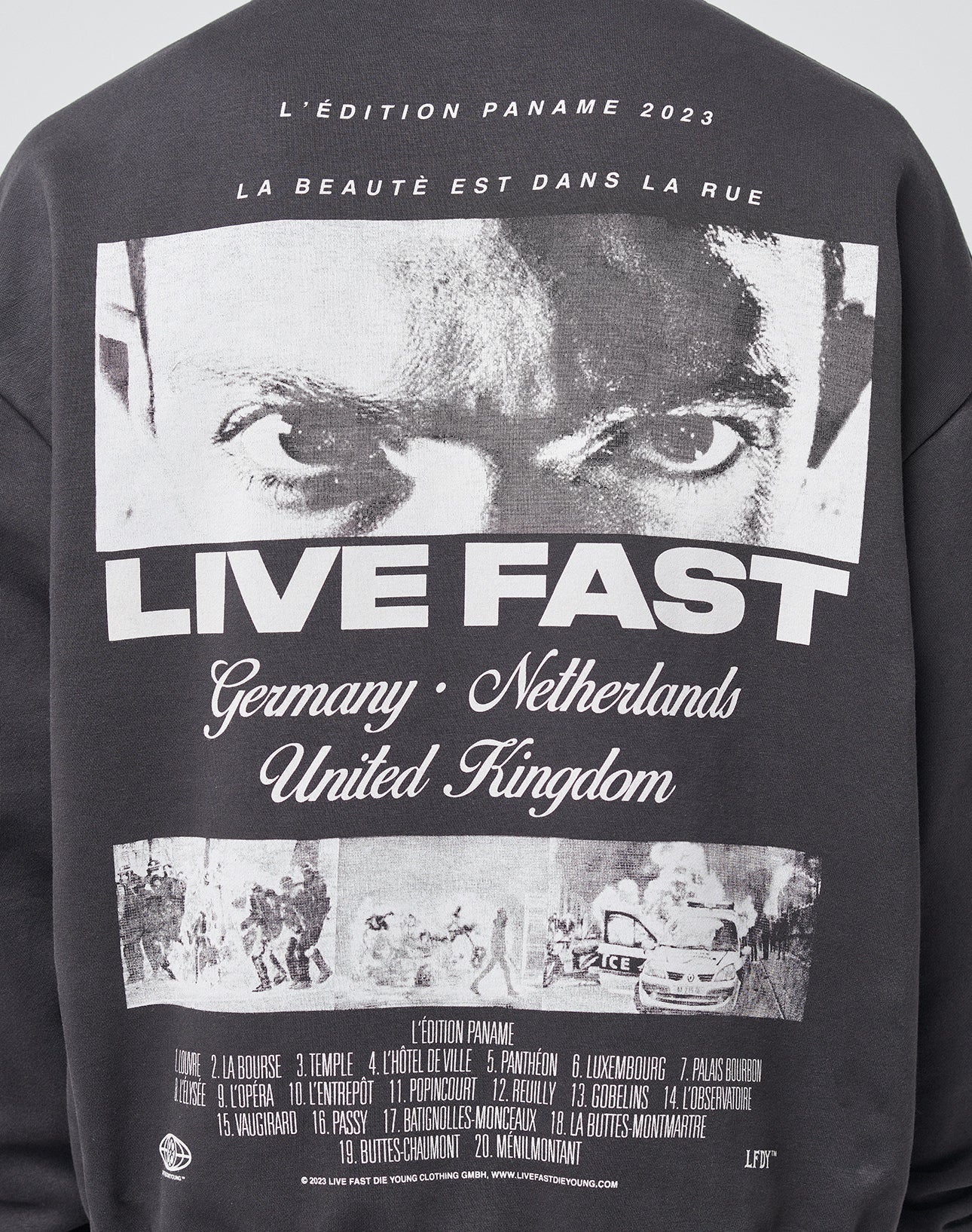 The LFDY Cinema Hooded by LIVE FAST DIE YOUNG is a black oversized sweatshirt with a bold eyes graphic, LIVE FAST text, country names like Germany and UK, and other details on the back. Made from a Baumwolle-Polyester blend.