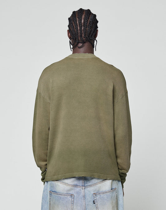 A person with braided hair is shown from the back, wearing the olive green LFDY Rib Knit Longsleeve by LIVE FAST DIE YOUNG and light blue jeans against a plain light gray background.