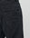 Close-up of the back pocket of black Wide Denim by LIVE FAST DIE YOUNG, featuring a black leather patch embossed with the brand name. The fabrics texture and detailed stitching are clearly visible.