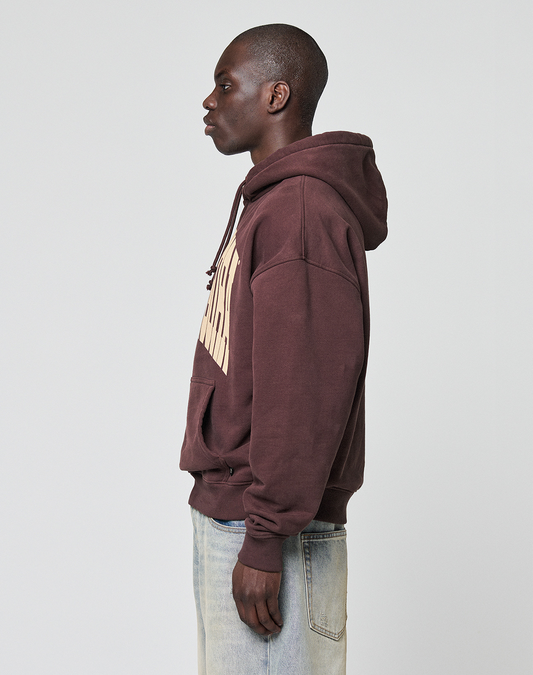 A person stands in profile against a plain background, wearing the oversize fit LFDY x Baba Angora Hoodie from LIVE FAST DIE YOUNG and light blue jeans, creating a relaxed, Baumwolle Pullover-inspired look.