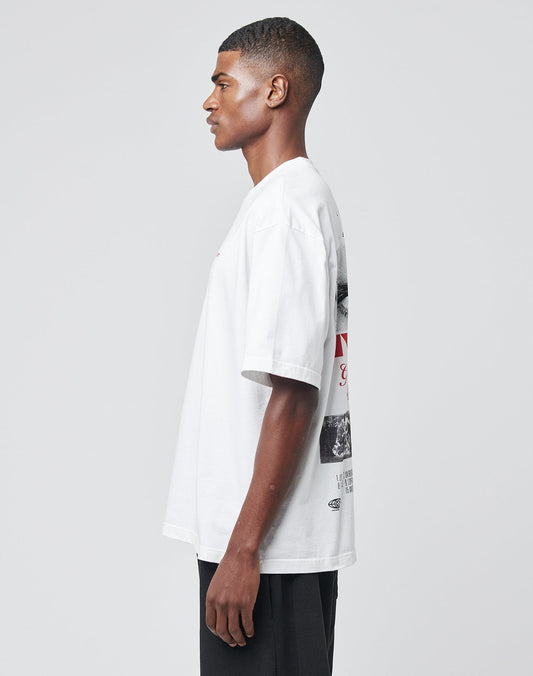 A young man stands in profile against a light gray background, wearing black pants and the LIVE FAST DIE YOUNG LFDY Cinema Tee—an Oversize Fit white T-shirt made of 100% Baumwolle with front and back prints featuring text and images.