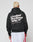 Someone with short, bleached blond hair faces away, wearing a LIVE FAST DIE YOUNG Basic 360 Hooded oversize black hoodie with bold white text and white athletic shorts with red stripes.