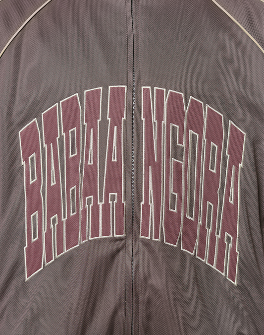 Close-up of the LFDY x Baba Angora Trackjacket by LIVE FAST DIE YOUNG, featuring bold maroon and white outlined BABAA NGORA lettering across the chest with striking Stick Applikation details.