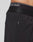 Close-up of a person wearing LIVE FAST DIE YOUNGs Live Fast Performance Shorts, featuring a regular fit, zippered pocket, and an elastic waistband with LIVE FAST in white letters.
