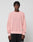 A person with short, textured hair wears the LIVE FAST DIE YOUNG LFDY Knit Sweater in light pink with dropped shoulders and black pants, standing against a plain light gray background.