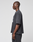 A man in profile against a light background wears the LFDY 40 Tee by LIVE FAST DIE YOUNG, a loose dark gray oversize-fit T-shirt made from 100% Baumwolle, paired with matching pants. His arms are relaxed at his sides as he looks ahead.