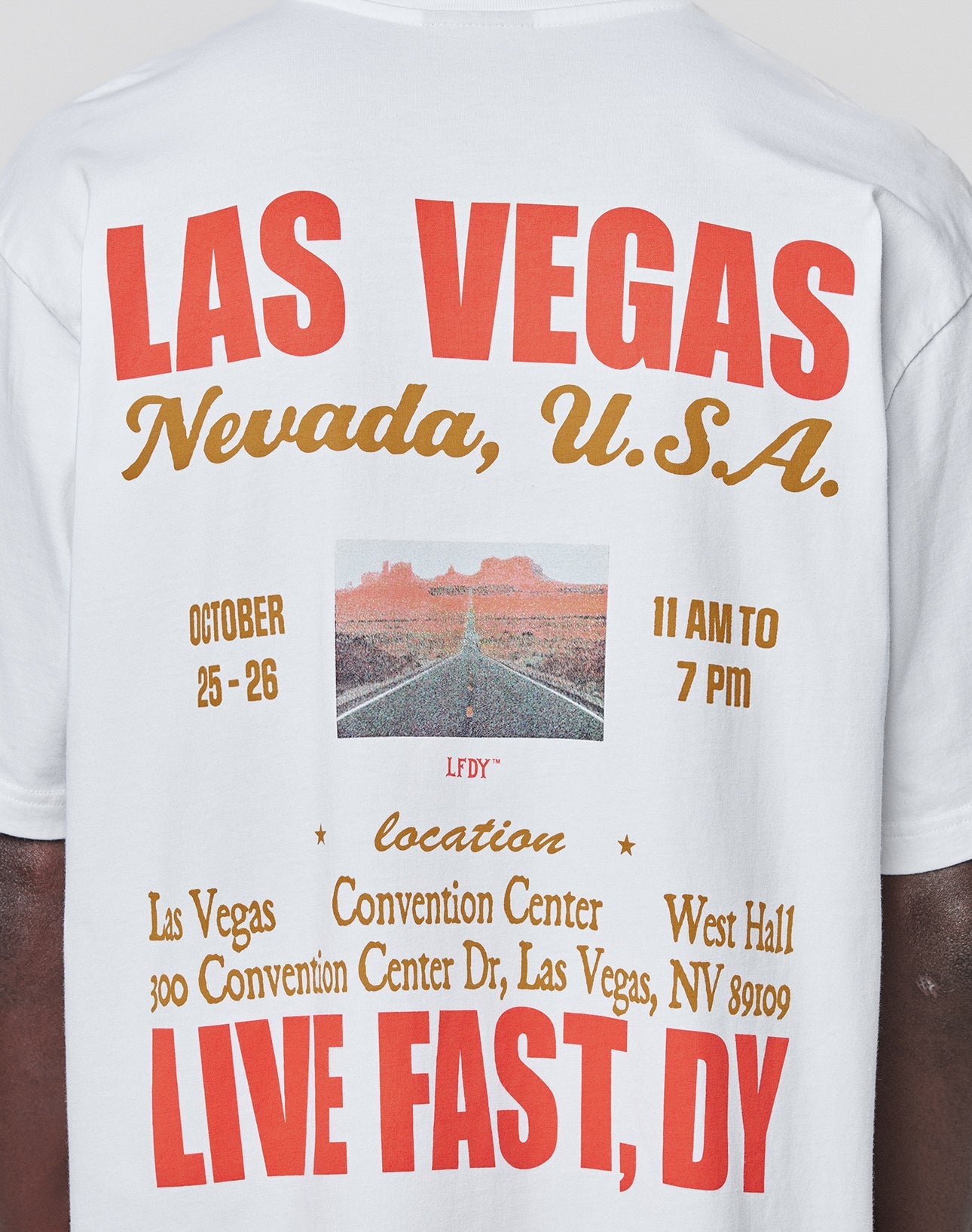 The Live Fast Vegas Tee by LIVE FAST DIE YOUNG is a white 100% Baumwolle shirt with bold red and gold LAS VEGAS, Nevada, U.S.A. text, event details, a desert road image, and LIVE FAST, DIE YOUNG at the bottom in an oversized fit.