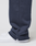 A close-up side view of a person wearing LIVE FAST DIE YOUNG LFDY Heavyweight Loungepants with frayed hems over white sneakers, standing against a plain white background.
