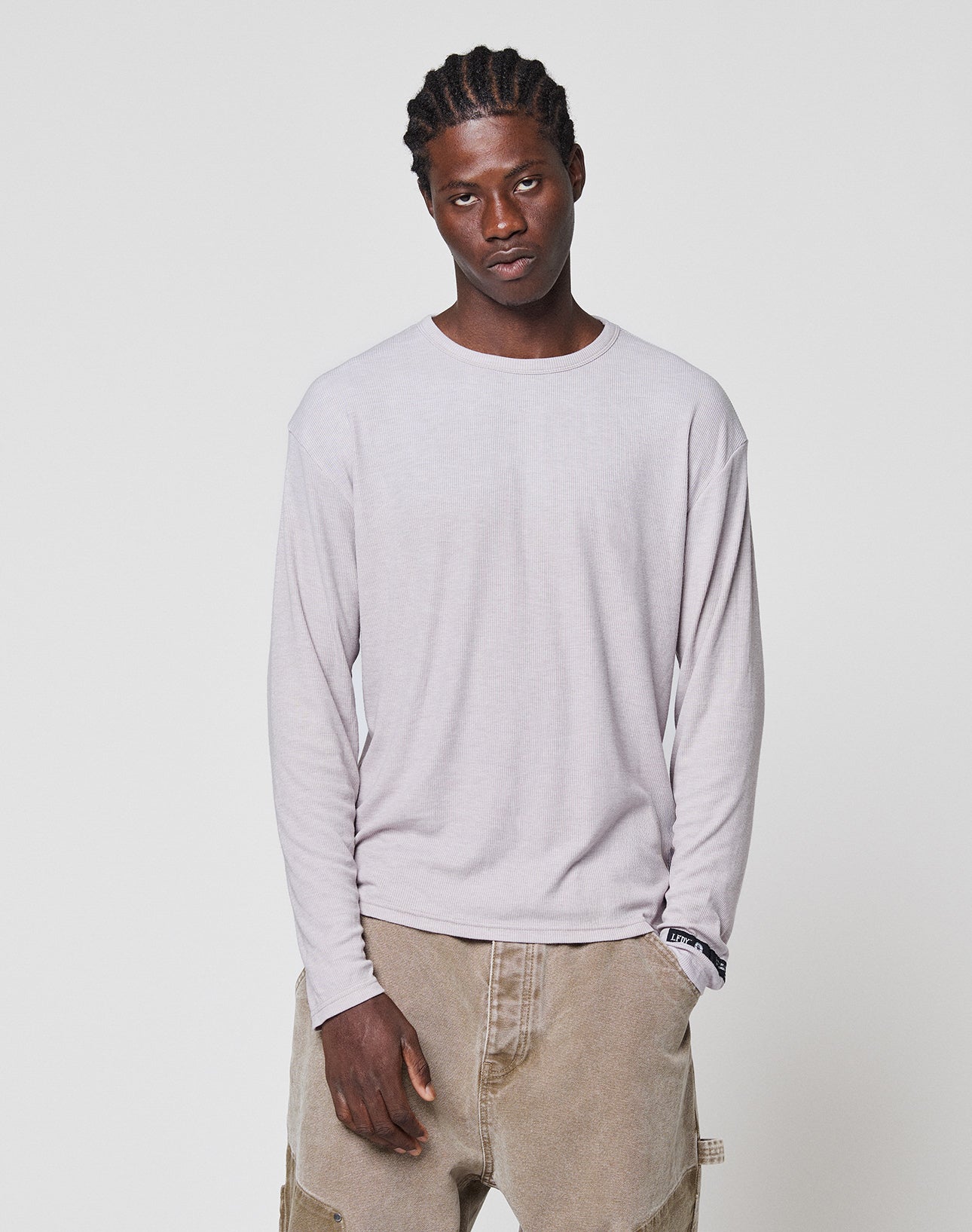 A man with cornrows wears the LIVE FAST DIE YOUNG LFDY Rib Longsleeve in light gray and beige cargo pants, posing against a plain white background with a neutral expression.