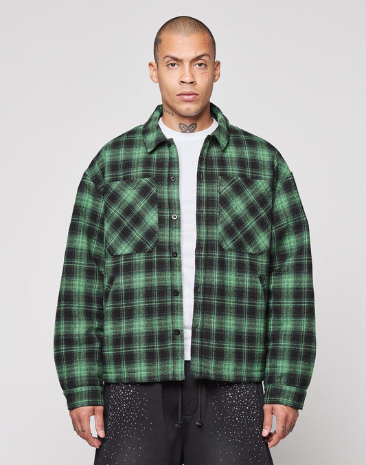 A person wearing a green and black LIVE FAST DIE YOUNG LFDY Padded Flannel over a white shirt stands facing forward against a plain light background.