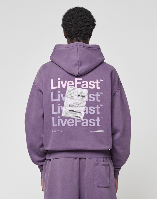 A person wearing a purple Basic Evidence Hooded and matching pants by LIVE FAST DIE YOUNG is seen from behind. The hoodie has “LiveFast” printed multiple times in white with a paper graphic, crafted from Baumwolle Polyester. | model