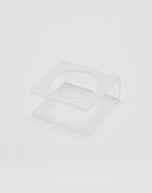 The LIVE FAST DIE YOUNG Live Fast Basketball is displayed on a clear, square acrylic stand with deep grooves and a circular cutout in the top panel, shown against a plain white background.