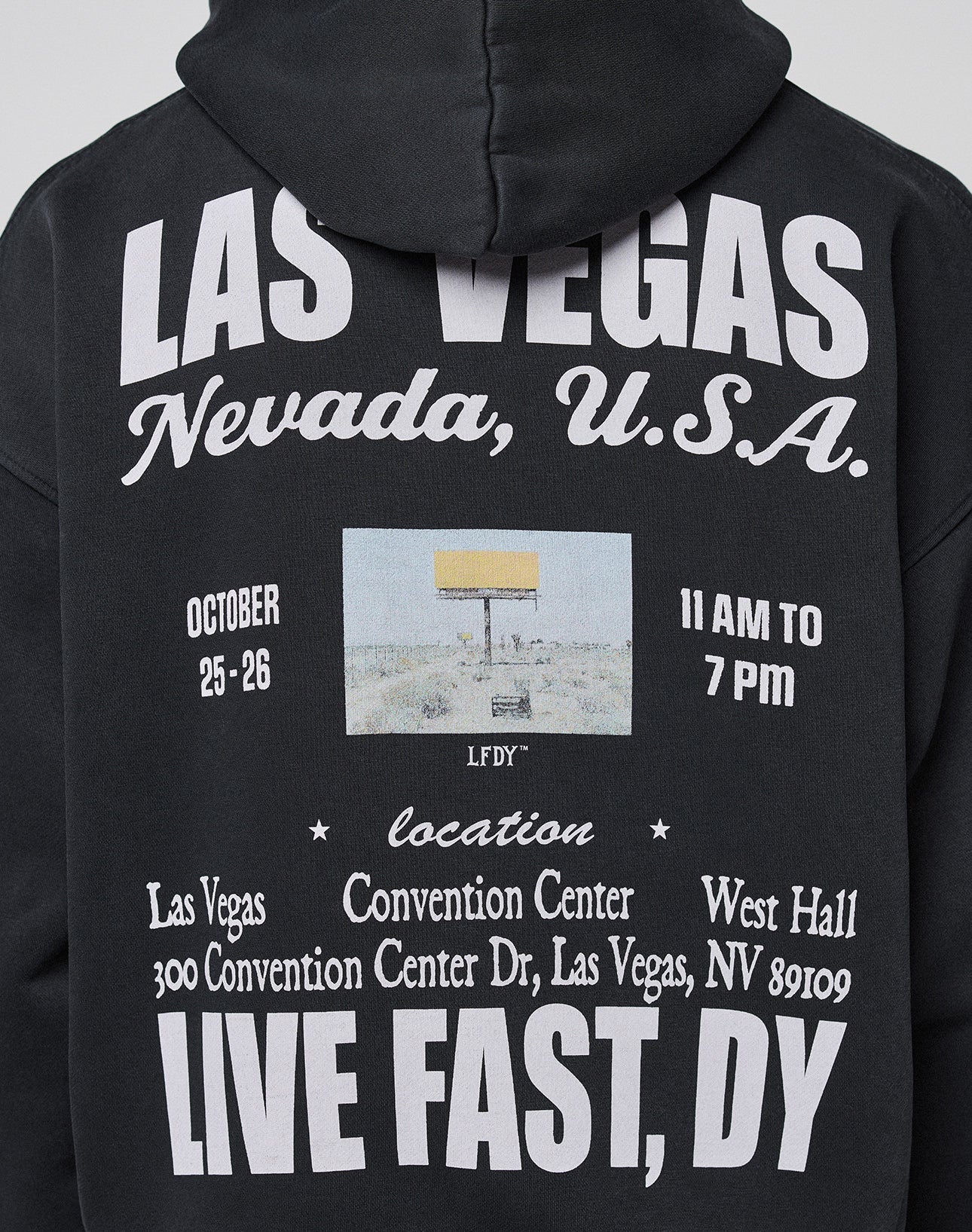 The Live Fast Vegas Hooded by LIVE FAST DIE YOUNG is a black oversized hoodie made with 65% cotton, featuring front and back prints with “LAS VEGAS Nevada, U.S.A.,” event details, a yellow billboard graphic, and bold “LIVE FAST, DY” on the back.