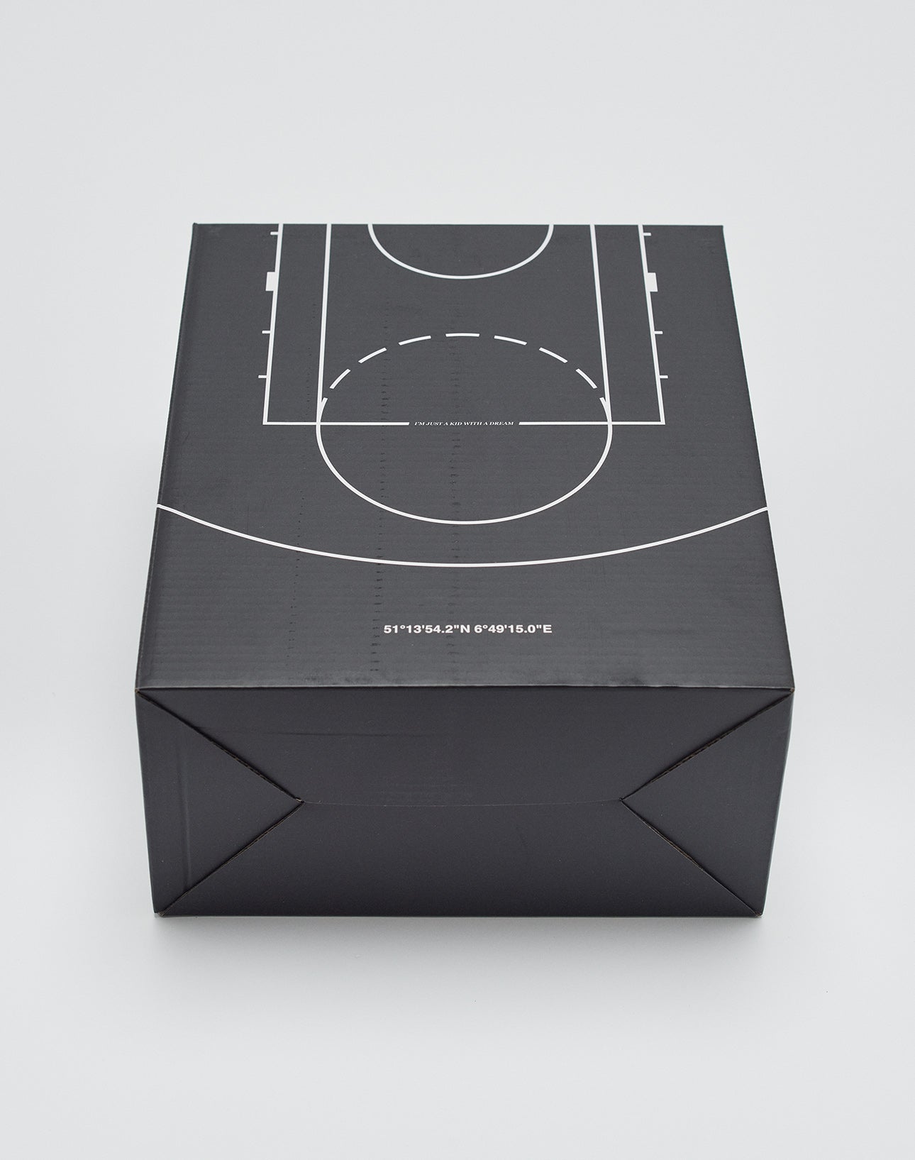 A black Live Fast Basketball box by LIVE FAST DIE YOUNG features a white court diagram on top and geographic coordinates along the front edge, displayed against a plain light background.