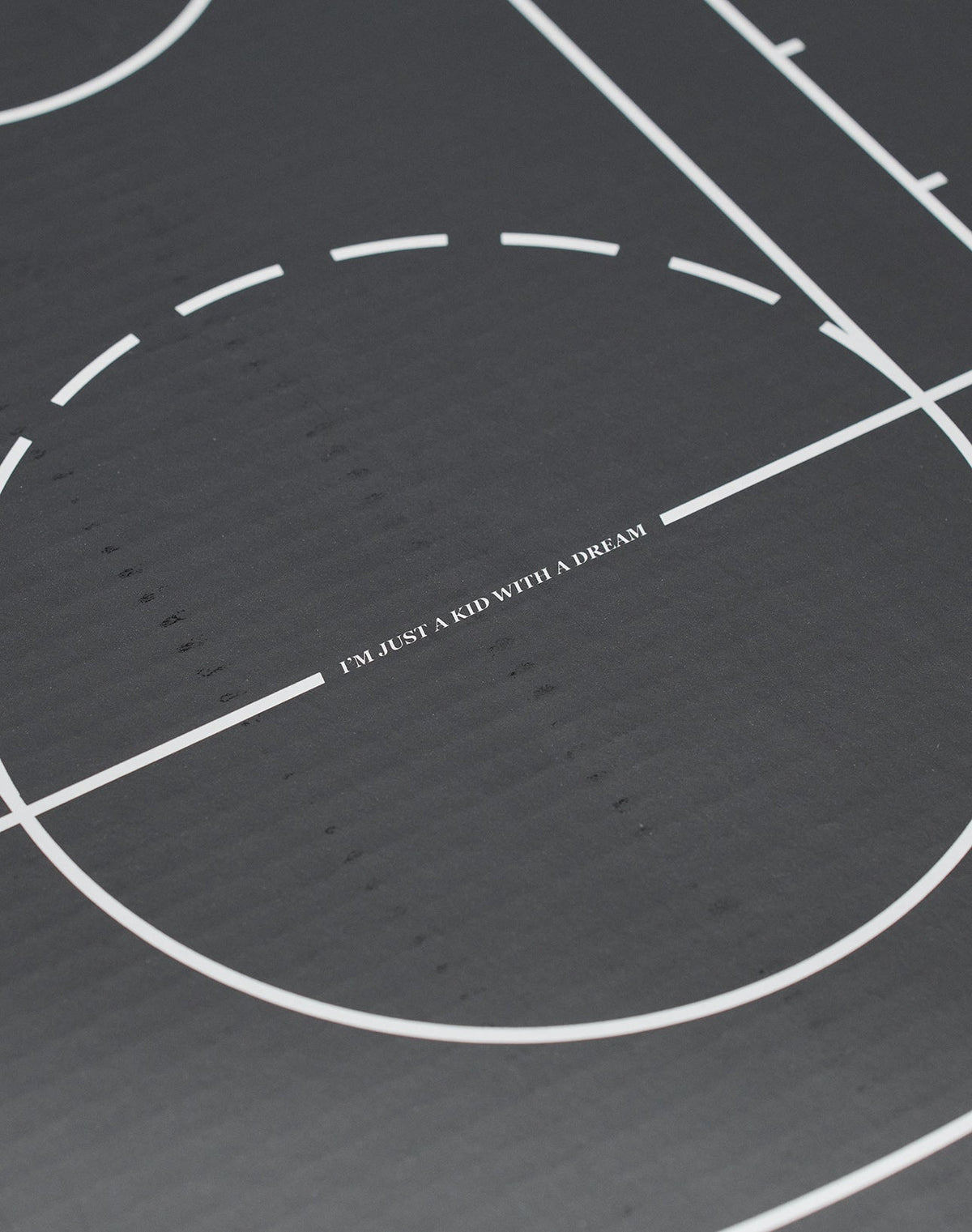 A close-up of a black Live Fast Basketball with white lines, LIVE FAST DIE YOUNG branding, and deep grooves, featuring IM JUST A KID WITH A DREAM at the center.