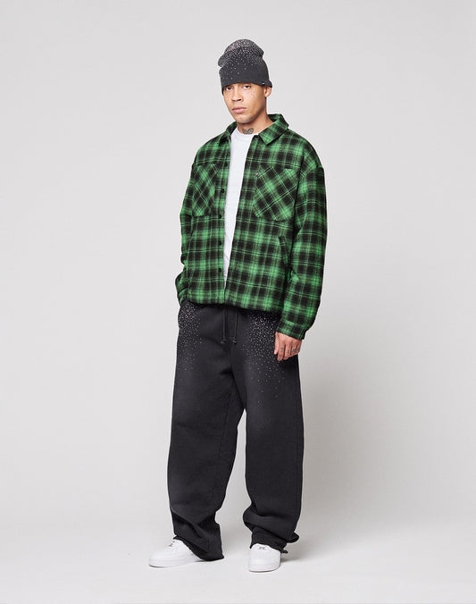 A person in a gray beanie, white shirt, loose black pants, white sneakers, and the LIVE FAST DIE YOUNG LFDY Padded Flannel stands against a plain light background.