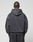 A person with a shaved head stands with their back to the camera, wearing the LFDY 40 Hooded oversize-fit dark gray sweatshirt and matching pants by LIVE FAST DIE YOUNG. The set features a kangaroo pocket and is made from cotton-polyester. The background is plain and light.