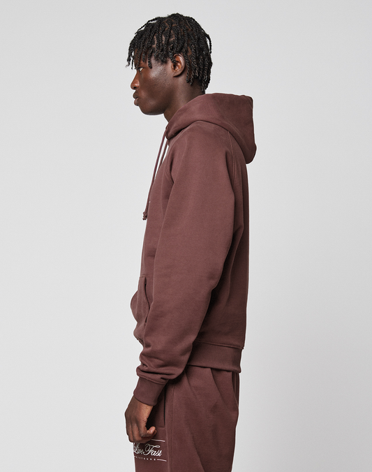 A person with short, twisted hair wears a brown LFDY Embroidery Hooded by LIVE FAST DIE YOUNG and matching sweatpants, standing in profile against a plain light background.