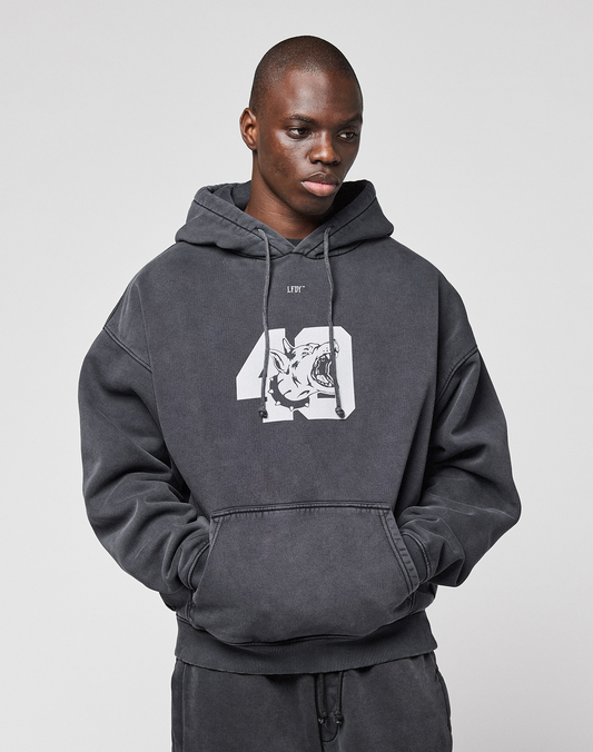 A person wearing the LFDY 40 Hooded by LIVE FAST DIE YOUNG, featuring a dark gray oversize fit with a white "40" and tiger graphic plus cozy Kangaroo-Tasche, stands against a plain light background.